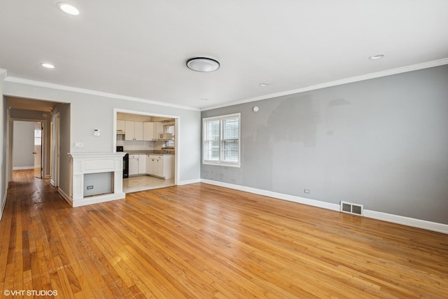 unfurnished living room with recessed lighting, light wood-style floors, crown molding, visible vents, and baseboards
