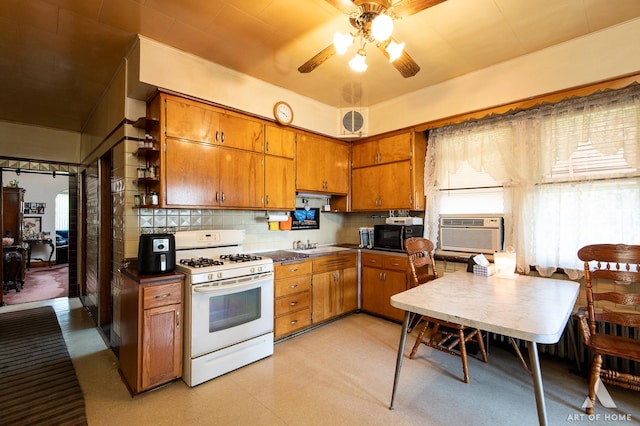 kitchen featuring brown cabinets, open shelves, black microwave, gas range gas stove, and a ceiling fan