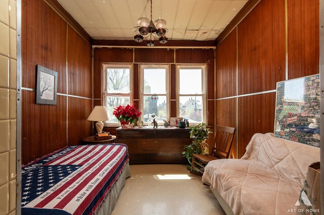 bedroom with a notable chandelier and wooden walls