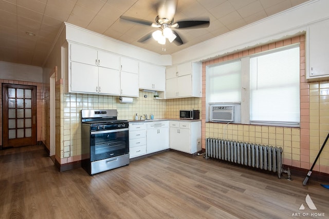 kitchen featuring radiator heating unit, stainless steel appliances, ceiling fan, and crown molding