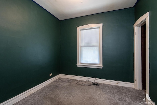 carpeted spare room featuring baseboards