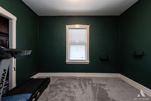 exercise room featuring carpet and baseboards