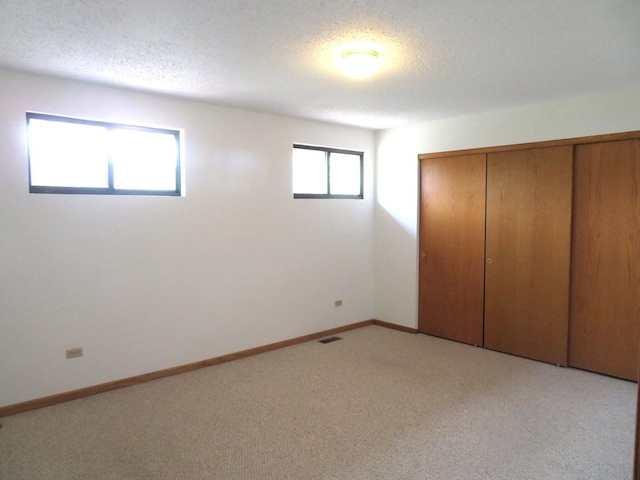 1321 Dresden Dr Unit C, Morris, IL 60450 - unfurnished bedroom with visible vents, a textured ceiling, a closet, and light colored carpet