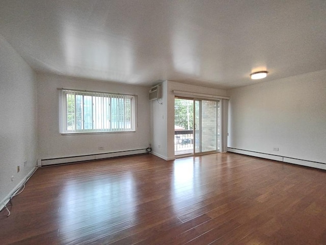 unfurnished living room featuring baseboard heating, wood finished floors, baseboards, and a wall mounted air conditioner