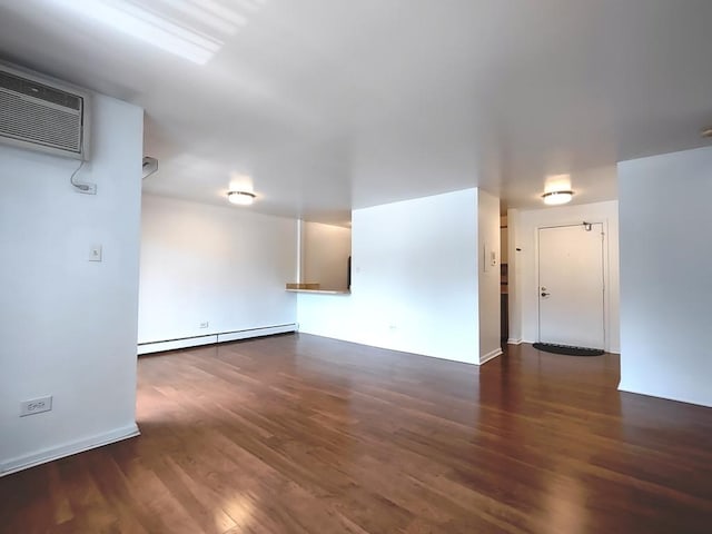 unfurnished living room featuring a baseboard radiator, wood finished floors, and an AC wall unit