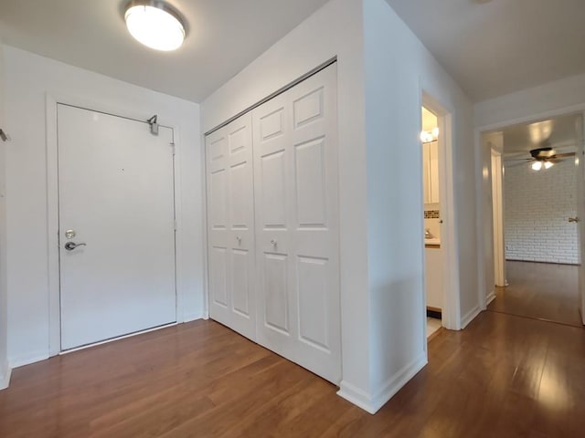 hallway featuring wood finished floors and baseboards