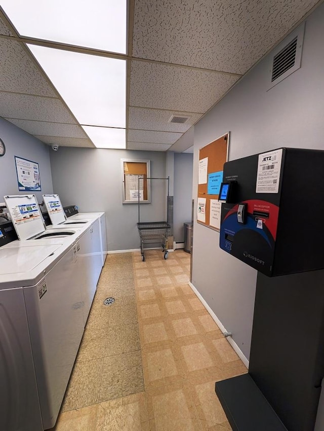 shared laundry featuring light flooring, baseboards, and washer and dryer