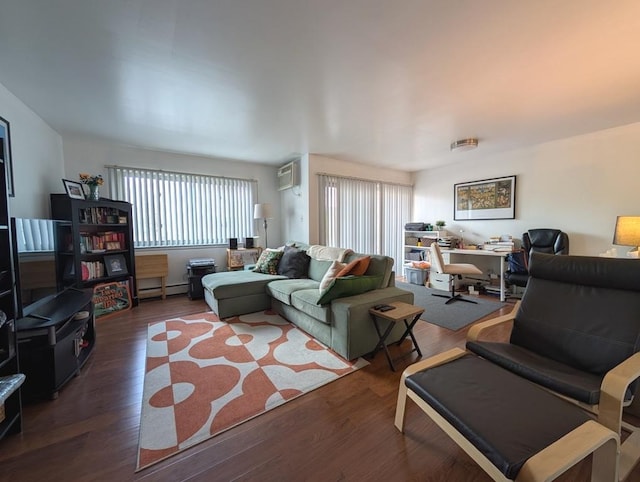 living area with a baseboard heating unit, wood finished floors, a desk, and a wall mounted AC