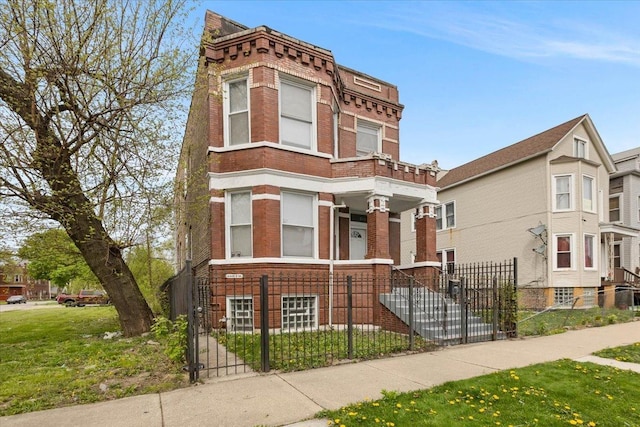 view of front of home with brick siding, a fenced front yard, and a gate