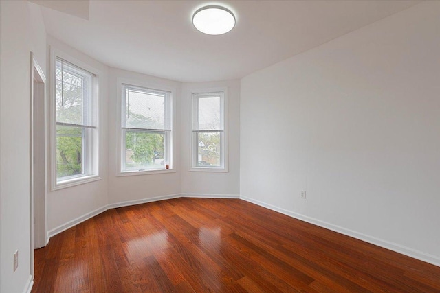 unfurnished room with wood finished floors and baseboards