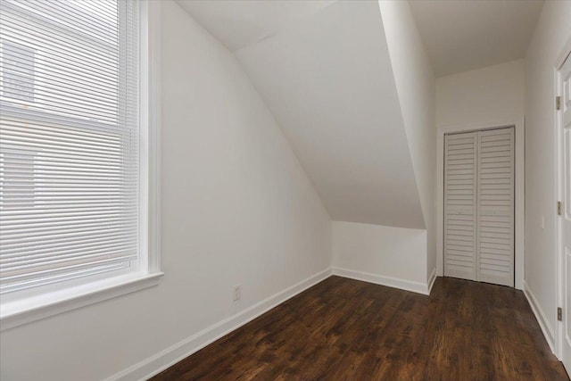 bonus room featuring vaulted ceiling, baseboards, and dark wood finished floors