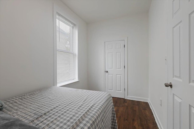 bedroom with dark wood-style flooring and baseboards