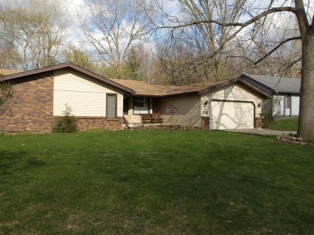 ranch-style house with a front yard, a garage, and brick siding