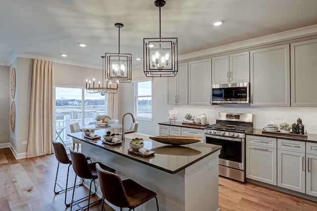 4187 Chelsea Manor Cir, Aurora, IL 60504 - kitchen with an inviting chandelier, decorative backsplash, ornamental molding, dark countertops, and appliances with stainless steel finishes