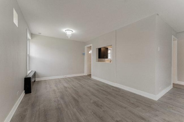 empty room featuring wood finished floors and baseboards