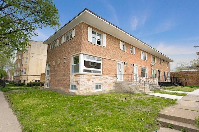 exterior space with brick siding and a front yard