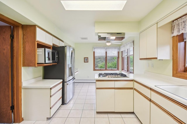 38413 N Tewes Ct, Beach Park, IL 60087 - kitchen with appliances with stainless steel finishes, under cabinet range hood, light countertops, baseboard heating, and light tile patterned floors