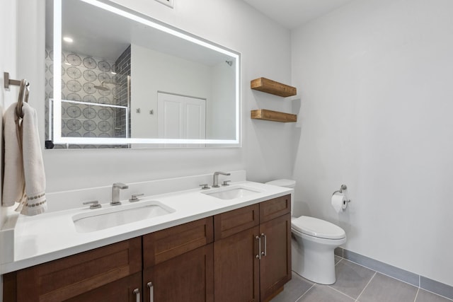 bathroom with a sink, tile patterned flooring, toilet, and double vanity