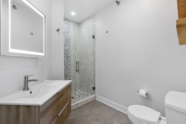 full bathroom with tile patterned flooring, a stall shower, vanity, baseboards, and toilet