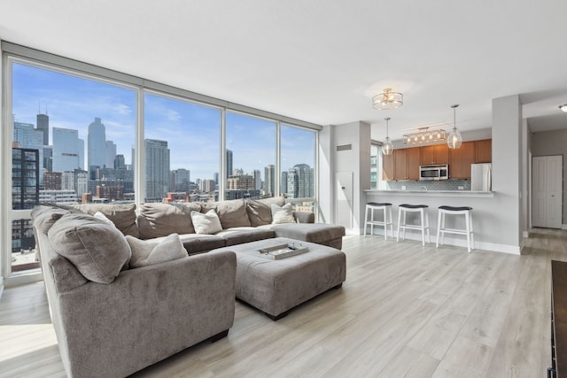 living room featuring light wood-style floors, a city view, and a chandelier