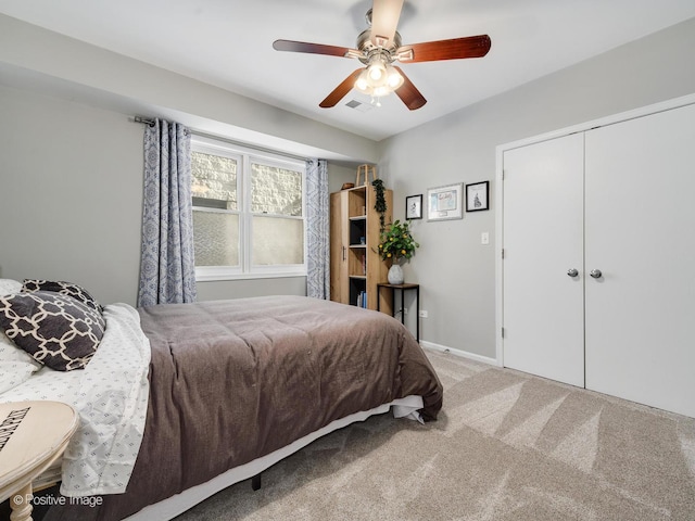 carpeted bedroom with a ceiling fan, a closet, and baseboards