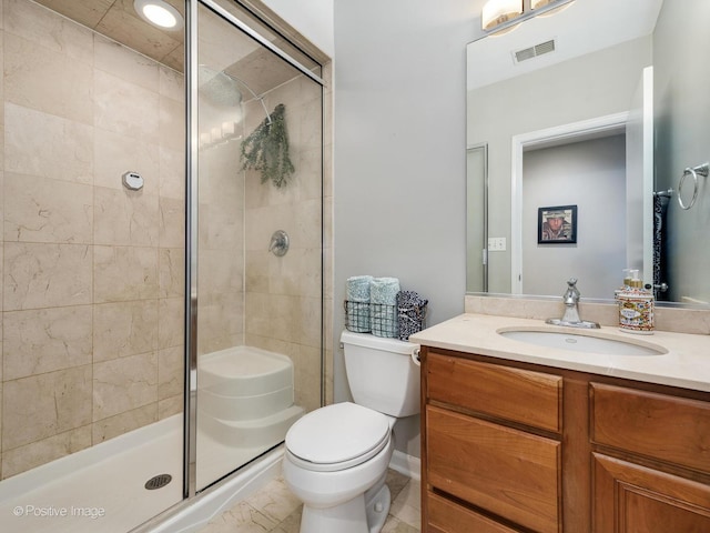 bathroom featuring a shower stall, toilet, and vanity