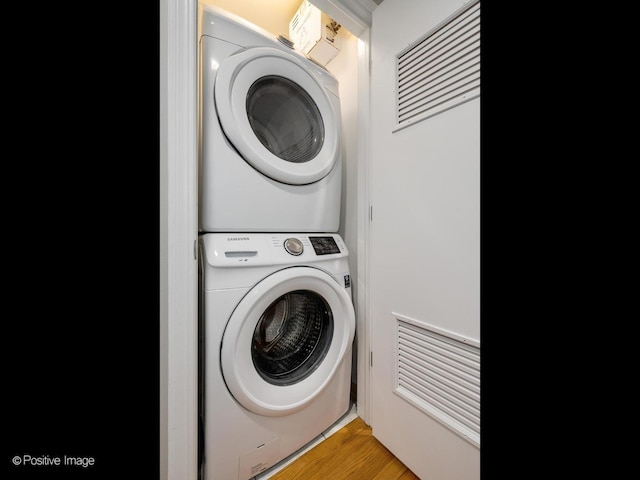 laundry area featuring estacked washer and dryer and light wood-style floors