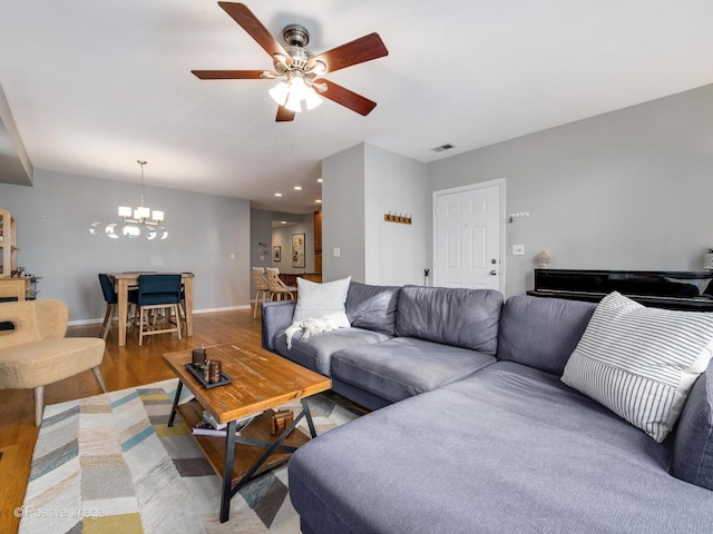living area with a chandelier, ceiling fan, baseboards, light wood-type flooring, and recessed lighting