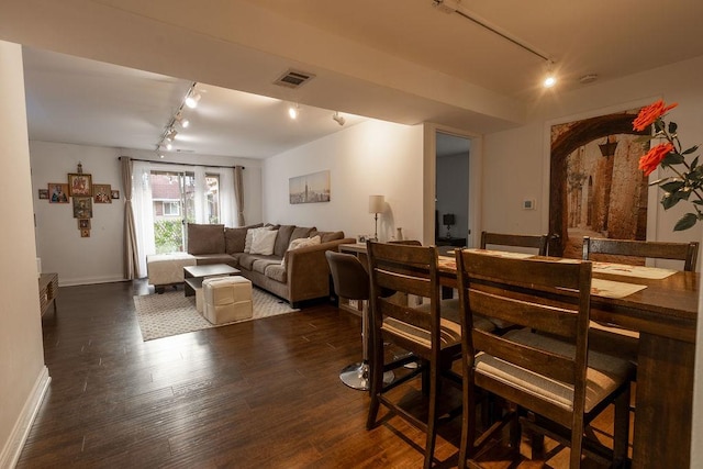 dining space with track lighting, baseboards, dark wood-type flooring, and visible vents