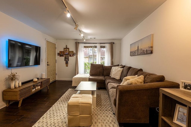 living area featuring dark wood-style flooring, baseboards, and track lighting