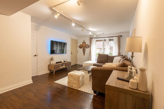 living area with baseboards, rail lighting, and dark wood finished floors