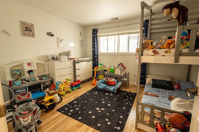 bedroom featuring visible vents and wood finished floors