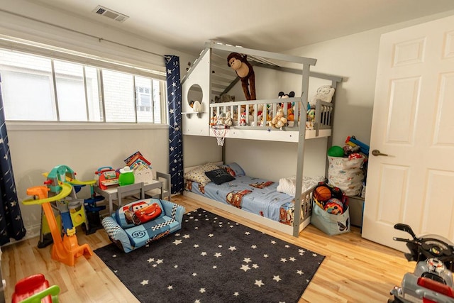 bedroom featuring visible vents and wood finished floors