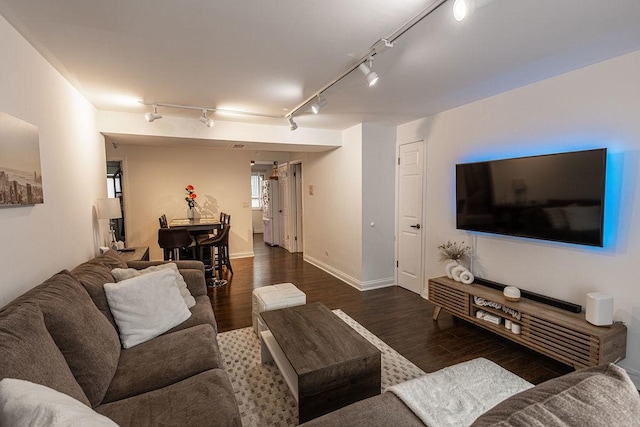 living area featuring track lighting, baseboards, and wood finished floors