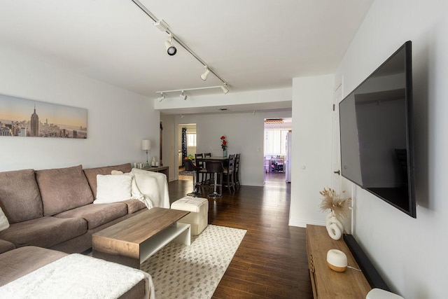 living room with baseboards, rail lighting, and dark wood finished floors