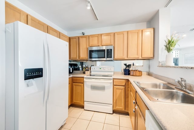 kitchen featuring white appliances, light tile patterned floors, a sink, and light countertops