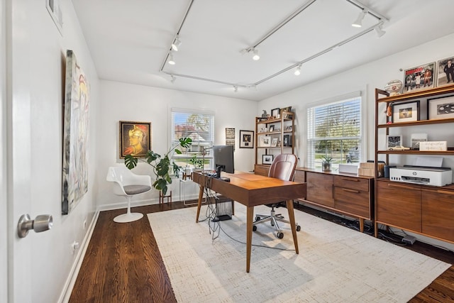 office space featuring visible vents, rail lighting, wood finished floors, and a wealth of natural light