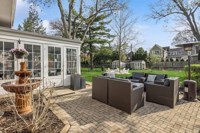 view of patio with an outdoor living space, french doors, an outbuilding, a shed, and a fenced backyard