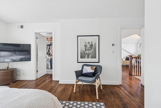 bedroom featuring a walk in closet, visible vents, wood finished floors, baseboards, and a closet