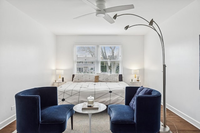 living area featuring baseboards, ceiling fan, and wood finished floors