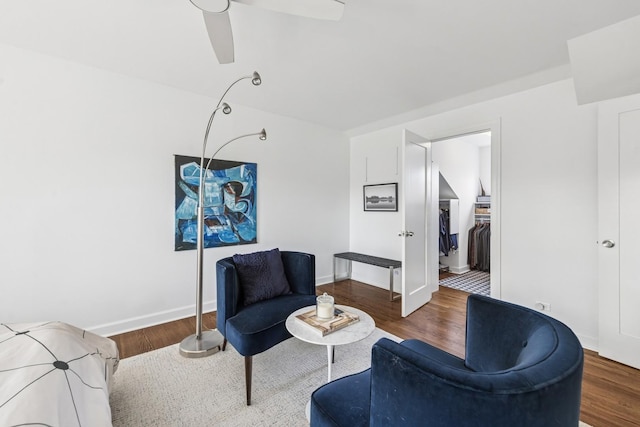 living room featuring baseboards, ceiling fan, and wood finished floors