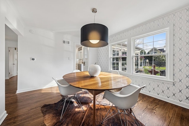 dining space featuring visible vents, ornamental molding, baseboards, and wallpapered walls