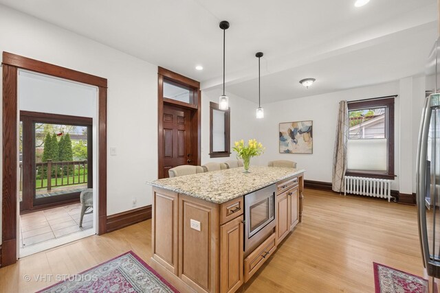 1625 Central Ave, Wilmette, IL 60091 - kitchen with appliances with stainless steel finishes, light stone countertops, light wood-type flooring, baseboards, and radiator heating unit
