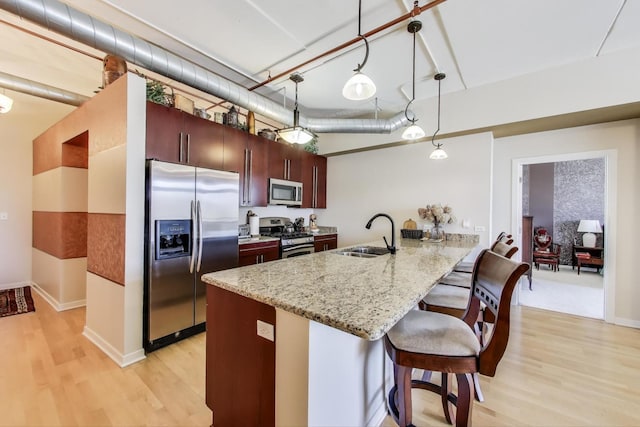 170 N NW Hwy Unit 410, Park Ridge, IL 60068 - kitchen featuring a breakfast bar area, a sink, light wood-style floors, stainless steel appliances, and a peninsula