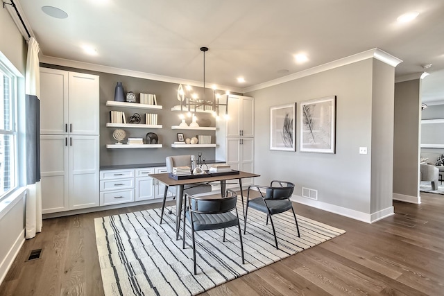 dining room featuring baseboards, dark wood-style floors, visible vents, a notable chandelier, and crown molding