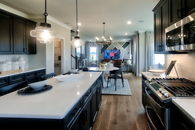 kitchen featuring a chandelier, stainless steel appliances, decorative light fixtures, light countertops, and dark wood-style floors