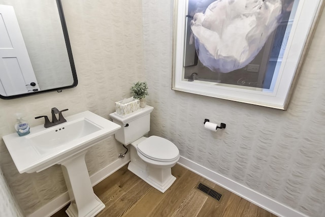 bathroom featuring toilet, visible vents, wood finished floors, and baseboards