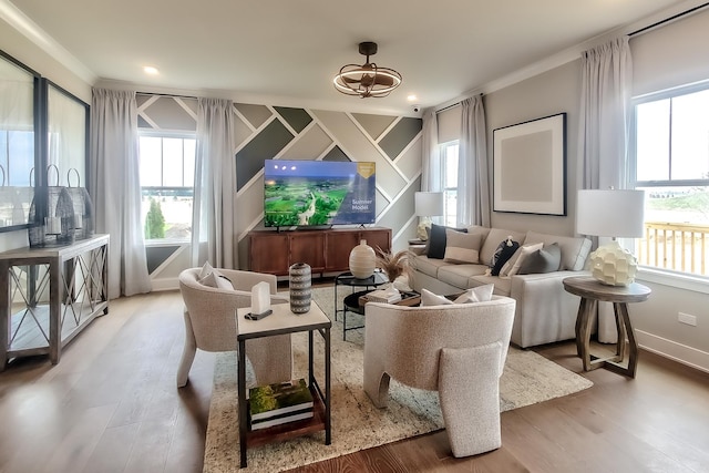 living area featuring ornamental molding, an inviting chandelier, wood finished floors, and plenty of natural light