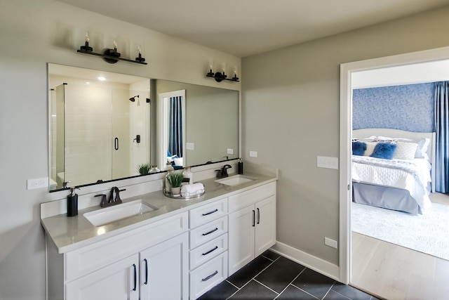 ensuite bathroom featuring double vanity, ensuite bathroom, a shower stall, and a sink