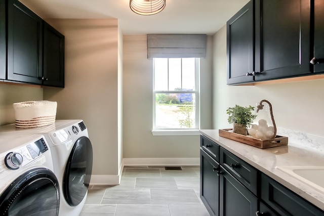 washroom with washer and dryer, cabinet space, visible vents, and baseboards